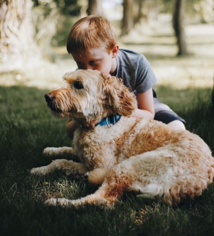 Un niño dándole cariño a su mascota